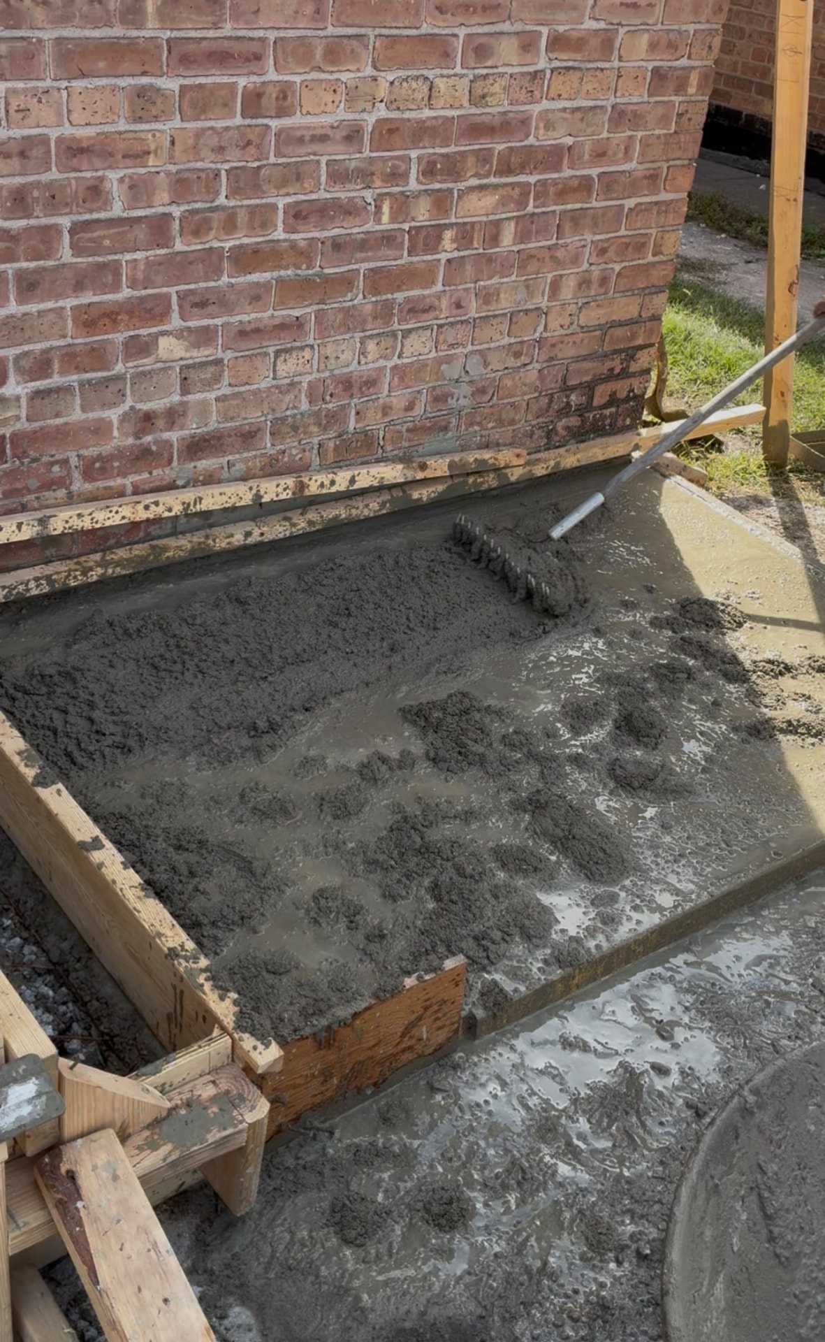 Wet concrete being raked level for a slab